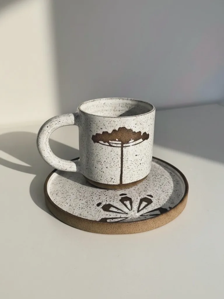 Caneca Araucária sobre o prato de mesmo desenho, na luz da manhã.